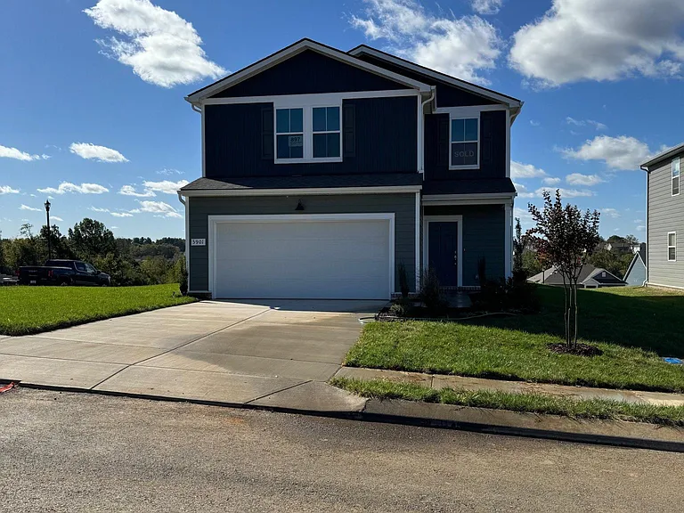 Front elevation of the home located on a large corner lot.