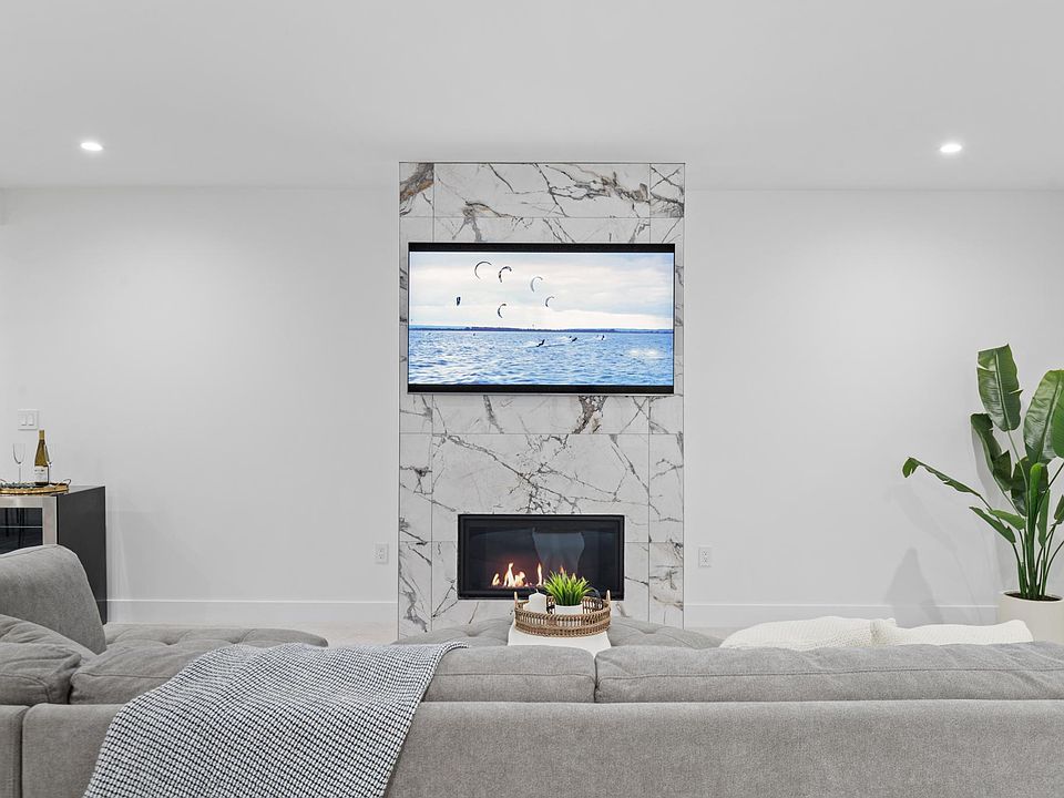 Living room with 65" SmartTV, sectional sofas with ottoman, and beverage refrigerator