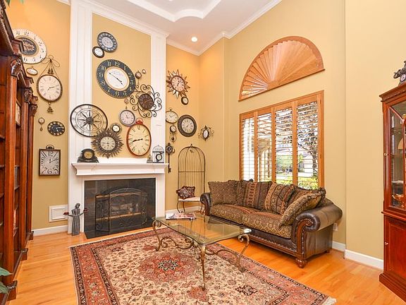 The hardwoods extend into the formal living room. This room has a fireplace and is tied together by plantation shutters.