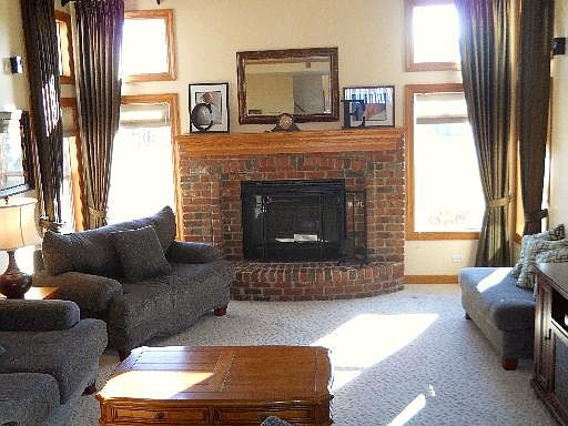 2-story family room boasts a brick fireplace along with designer window treatments.