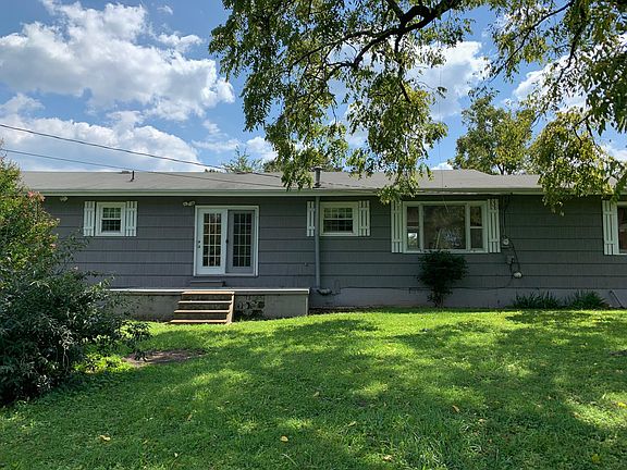 Back of house with large backyard and back porch