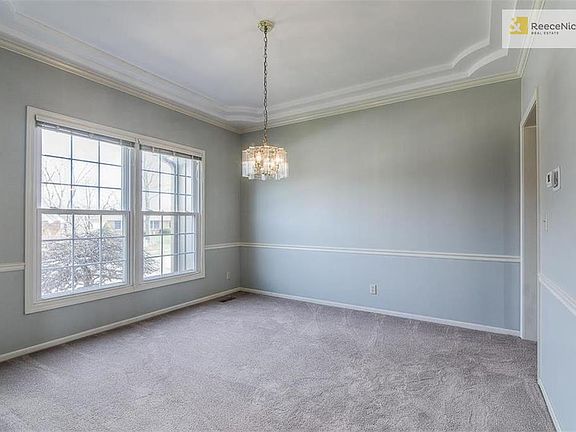 Formal dining room with wainscoting and coffered ceiling.