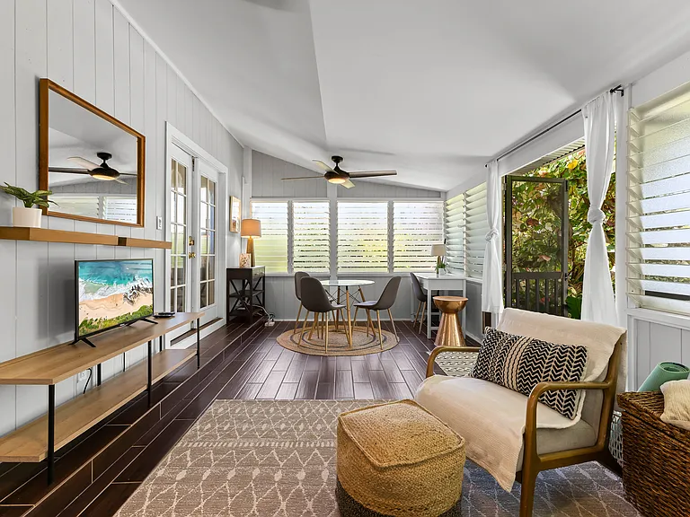 Enclosed lanai adds additional living space, a futon sofa, chair, TV, small dining set for 3-4, and a desk. Two large fans and lots of windows keep this area cool.