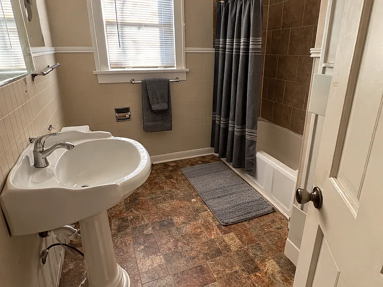 Upstairs full bath with tiled shower/tub and extra cabinets for storage