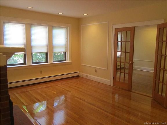 Spacious Living Room looks out on trees and flowers. French doors to lead to formal Dining Room