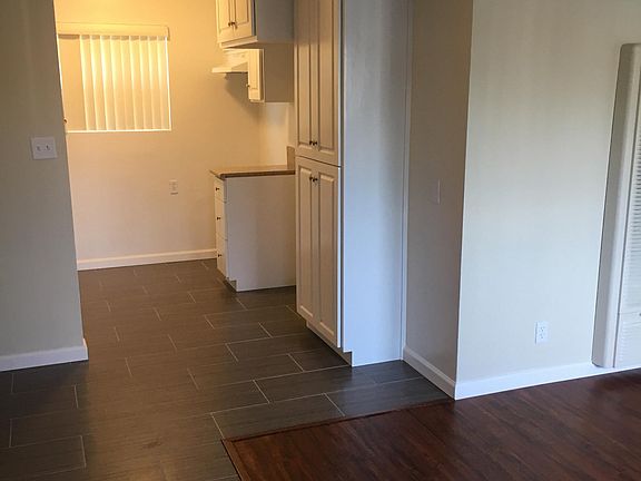 Tile in kitchen and dining area. Wood Laminate flooring in living room.