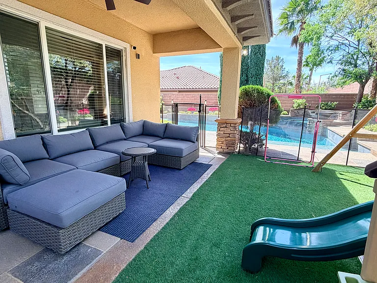 Outdoor covered seating area with child safety fence view of pool