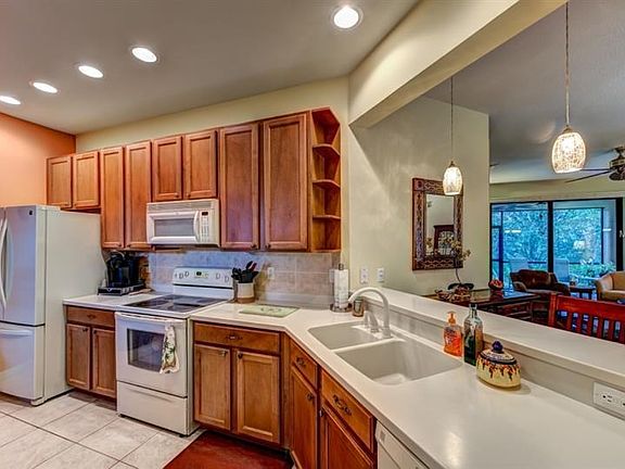 Lots of cabinets, with Corian counter tops, top bottom refrigerator