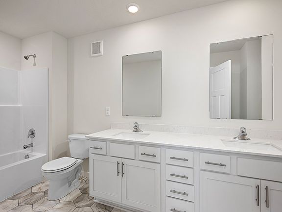 The master bathroom has a dual sink vanity and a tub shower combo