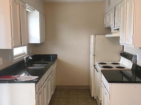 Galley Kitchen with Range, refrigerator and dishwasher.
