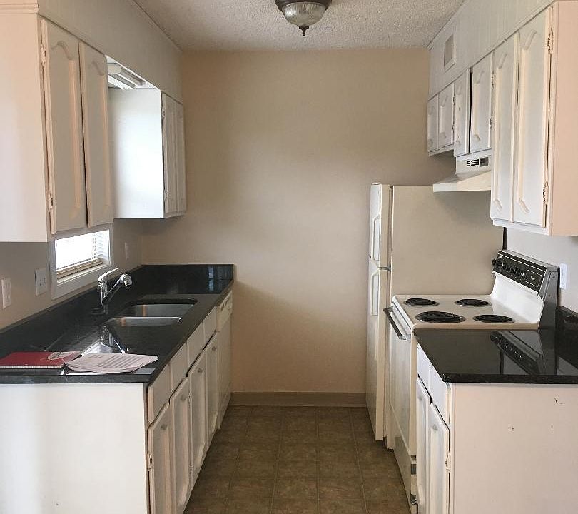 Galley Kitchen with Range, refrigerator and dishwasher.