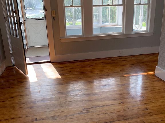 Living room via big front porch. Hardwood floors through, newly refinished. Entire apartment is newly painted in coastal colors of grey and white.