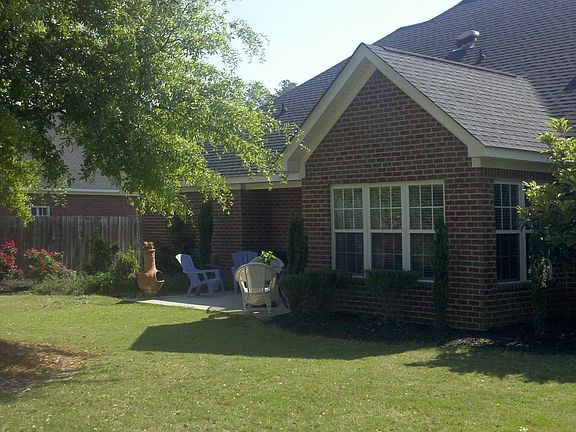 Park-like backyard features flowers, fruit trees, herbs, & custom play area