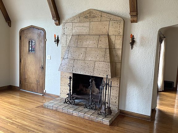 Living room with vaulted ceilings original light fixtures and fireplace with stenciling