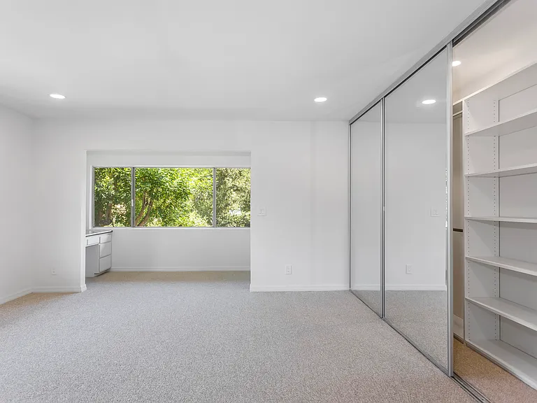Huge primary bedroom includes work area plus private area. Custom closet spans wall-to-wall.