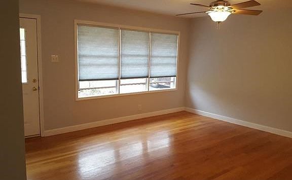 Open light and bright living room with an abundance of windows and wood floors!