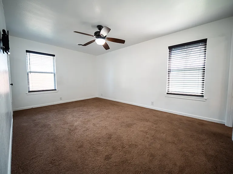Additional living space with ceiling fan and multiple windows