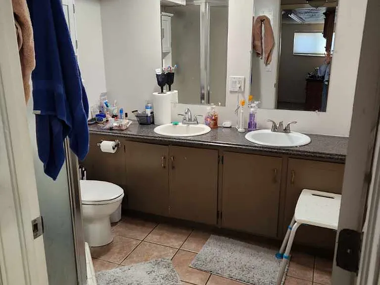 Downstairs bathroom with standup shower, toilet, and 2 sinks.