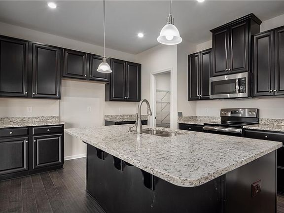 View of kitchen featuring gourmet island & espresso cabinetry - illustrative purposes only. 