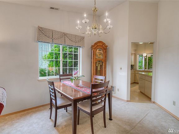 The formal dining room is right next to the kitchen and has vaulted ceilings.