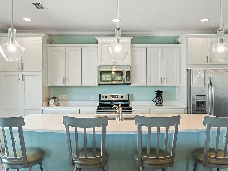 Stocked kitchen with quartz counters and large island.