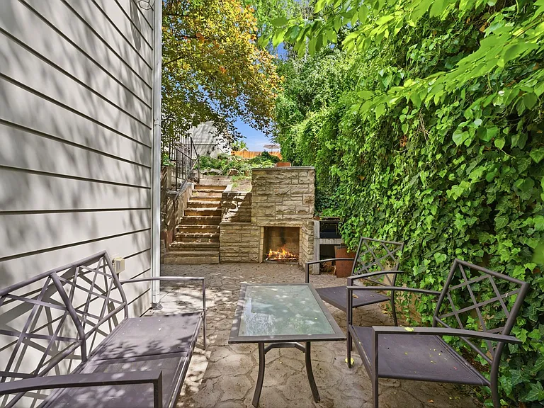 Additional seating in the side yard with built in outdoor fireplace and grill.