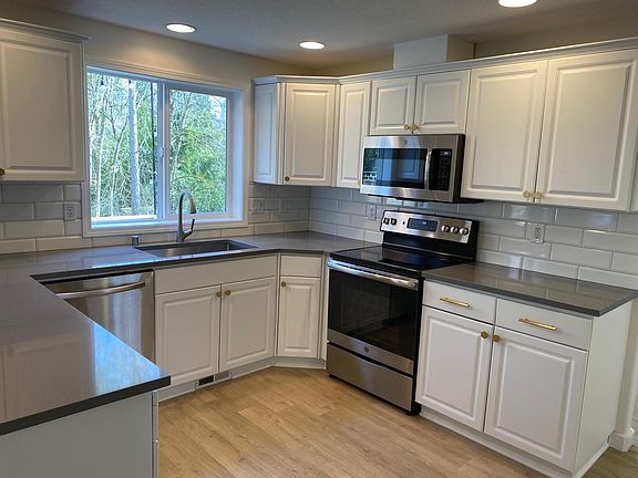 Upgraded kitchen w/ quartz counters, contemporary backsplash & hardware, stainless steel appliances