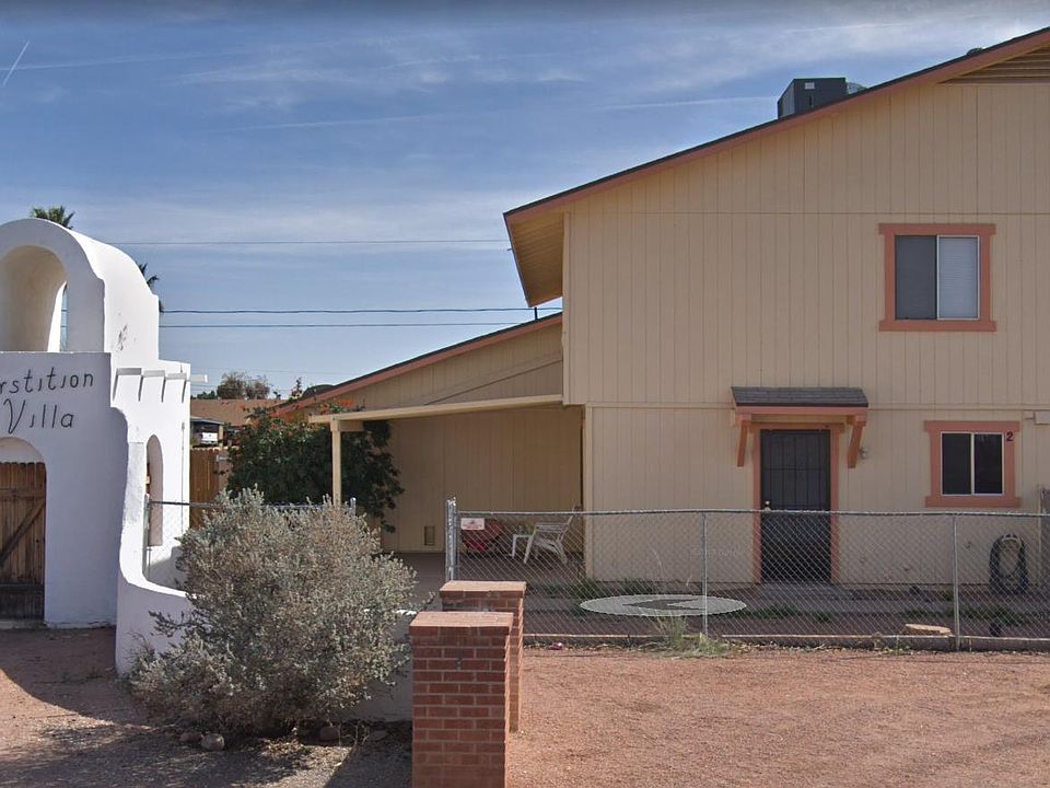 Front of apartment, fenced-off front yard with covered patio