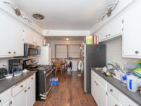 New laminate flooring in eat in kitchen with stainless steel appliances and new counters and lighting.
