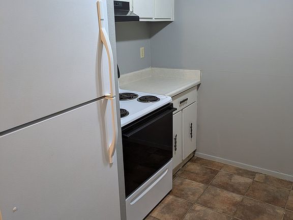 Kitchen showing right side with range and oven and refrigerator.