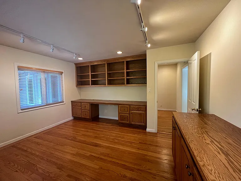 Private office is beautifully appointed with built-in wall desk, shelves and cabinetry. This versatile space may also serves as a fourth bedroom.