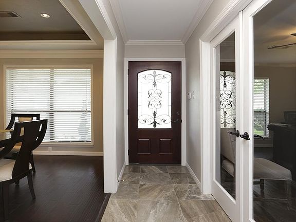 Mahogany wood door is accentuated with porcelain tile flooring as you enter into this custom detaile