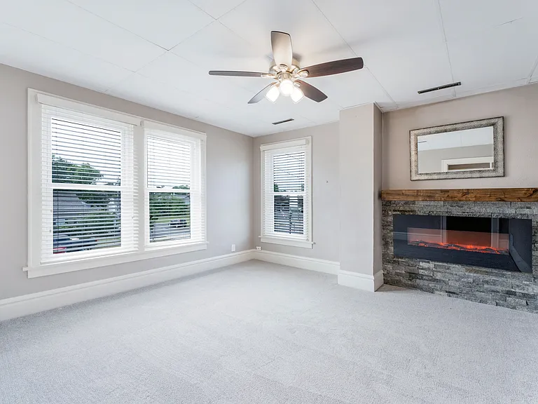 living room with electric fireplace with custom stone surround and mantel