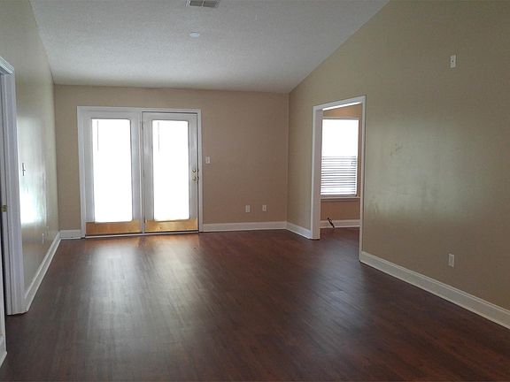 Living room with vaulted ceiling and bonus room off to the right.