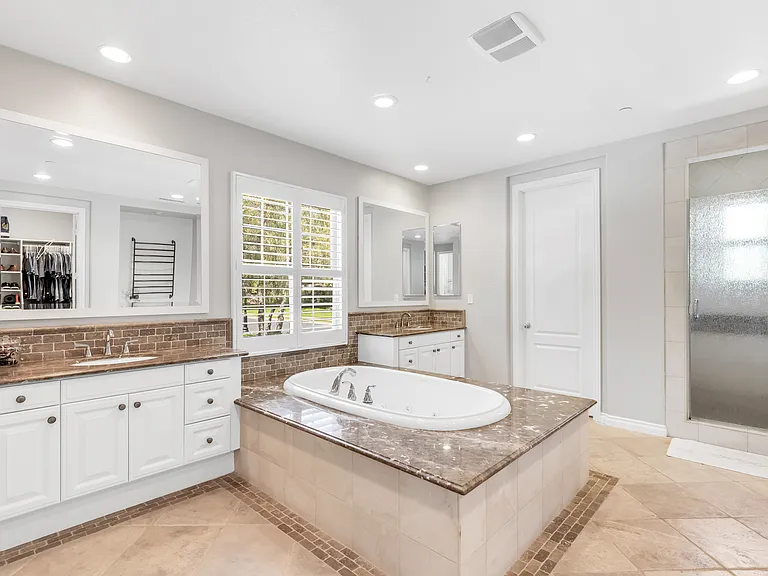 Welcome to your primary bath, dual vanities, tub, and spacious walk-in closet!