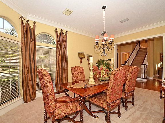 The elegant dining room is enhanced with updated lighting and custom draperies!