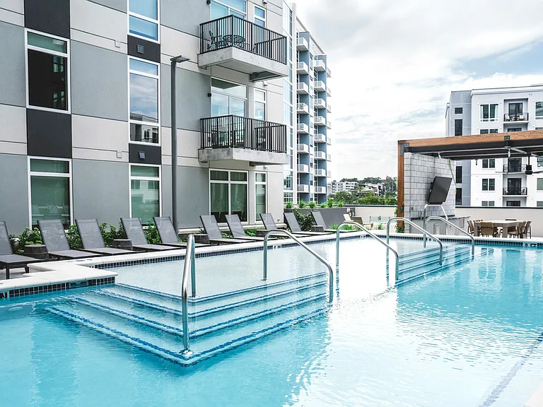 Resort-inspired heated pool with lounge areas
