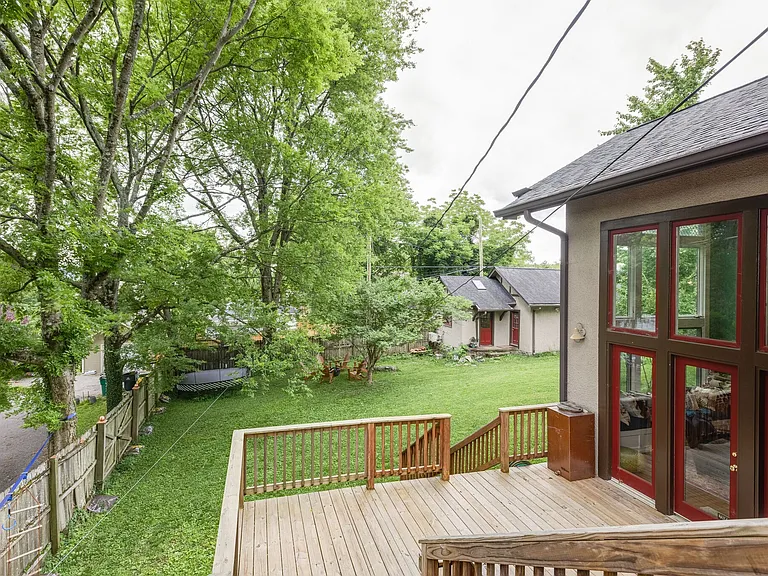 Large backyard with deck, mature trees, and space for outdoor entertaining.