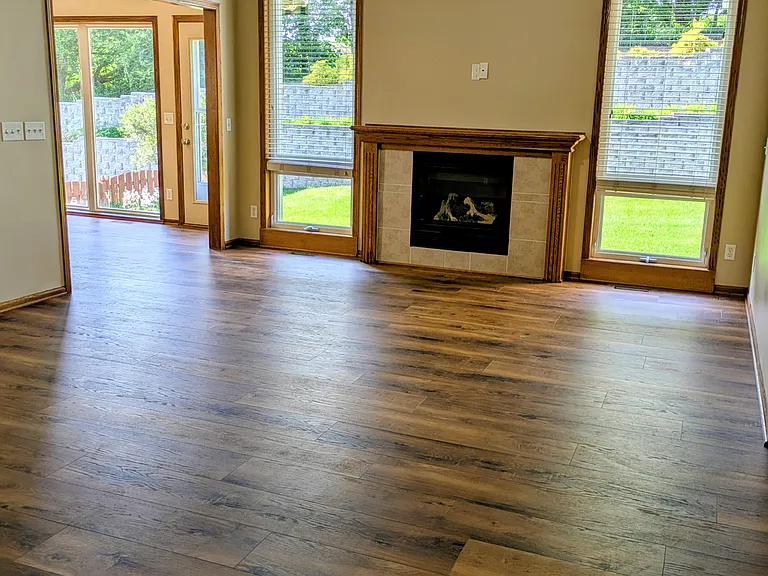 The Living room gas fireplace is flanked by floor-to-ceiling windows with a great view of the landscape. Blinds for privacy.