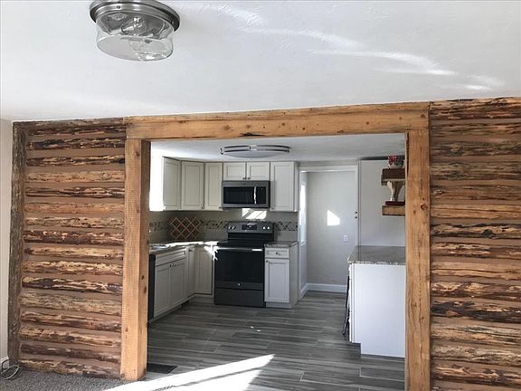 Exposed Log beams with view to kitchen from living room