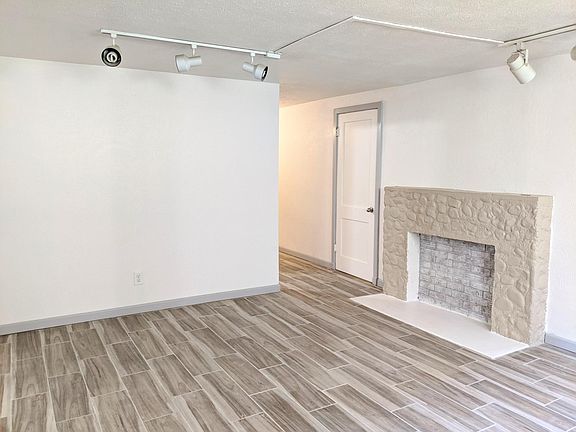 Open living room with decorative fireplace, and two windows.