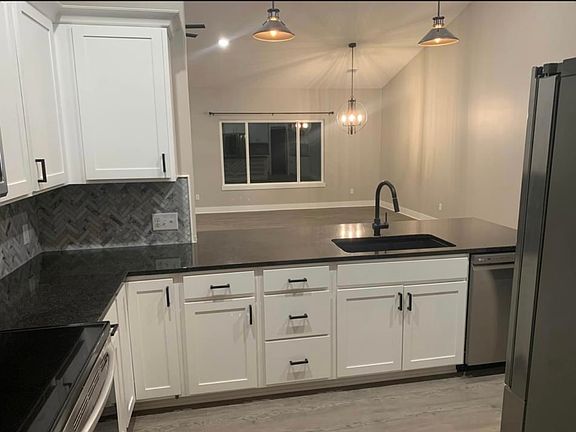Kitchen view of dinning area with large view out window overlooking deck and waterway.