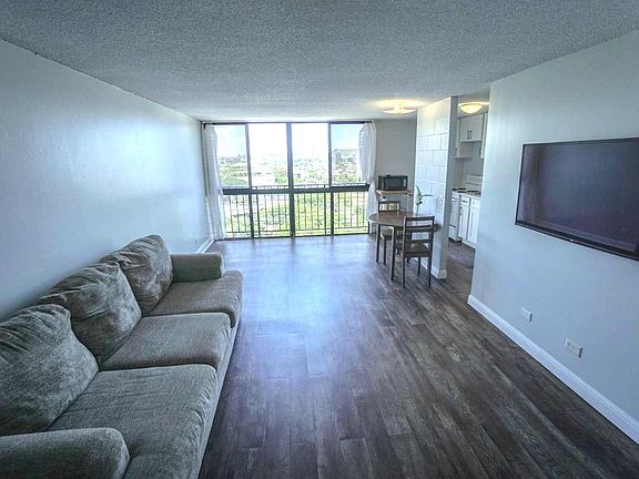 Spacious and airy living room with mounted smart TV.