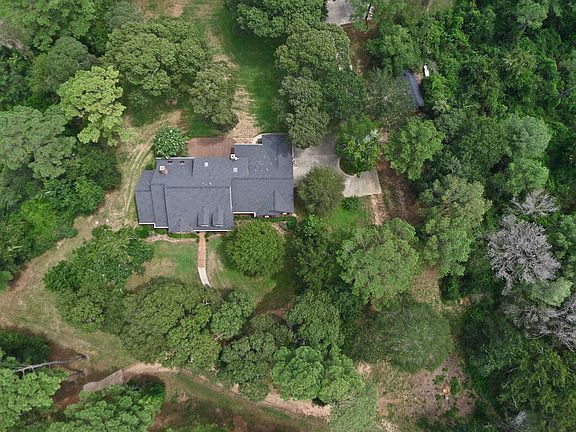 Beautiful hardwood and softwood trees surround the home
