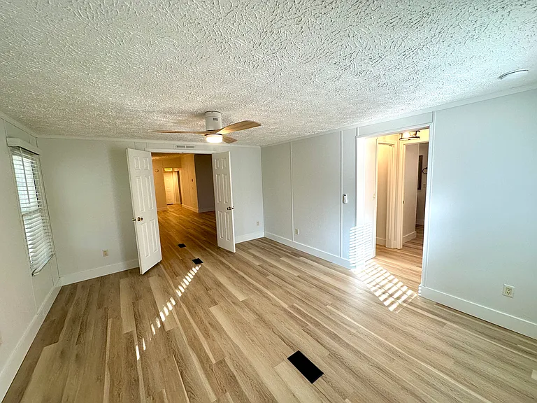 Primary Bedroom with French Doors leading out into the living area. New ceiling fan, window blinds, smoke detector.