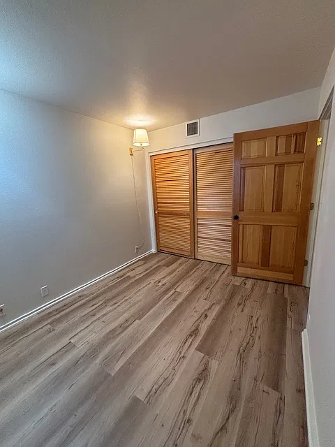 2nd bedroom, left of the front door. The room has a window and a large closet