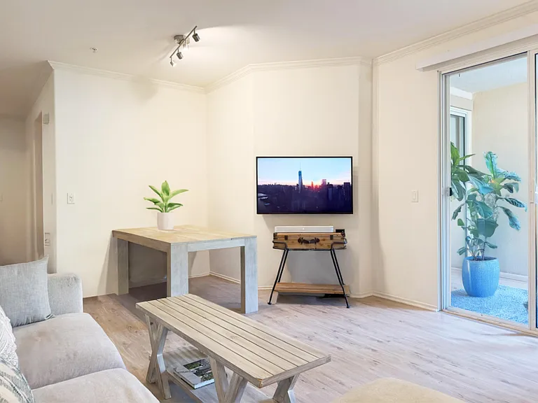 Open living area with comfortable seating, Apple TV, Sonos sound, dining table & glass doors leading to outdoor patio.