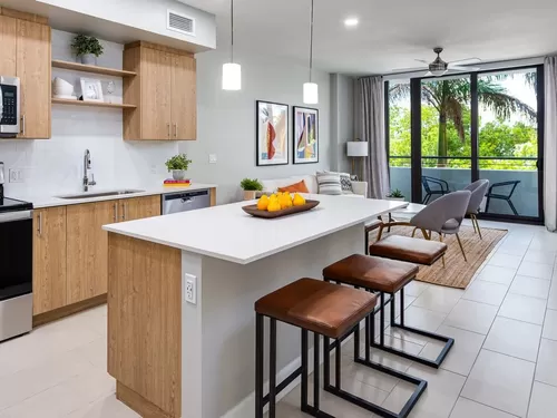 Open concept kitchen with quartz countertop, island, stainless steel appliances and tile backsplash - Avalon Doral