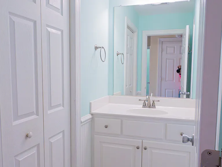 downstairs shared bathroom. Shower/tub combo in a separate room to the right. Washer/dryer in the closet