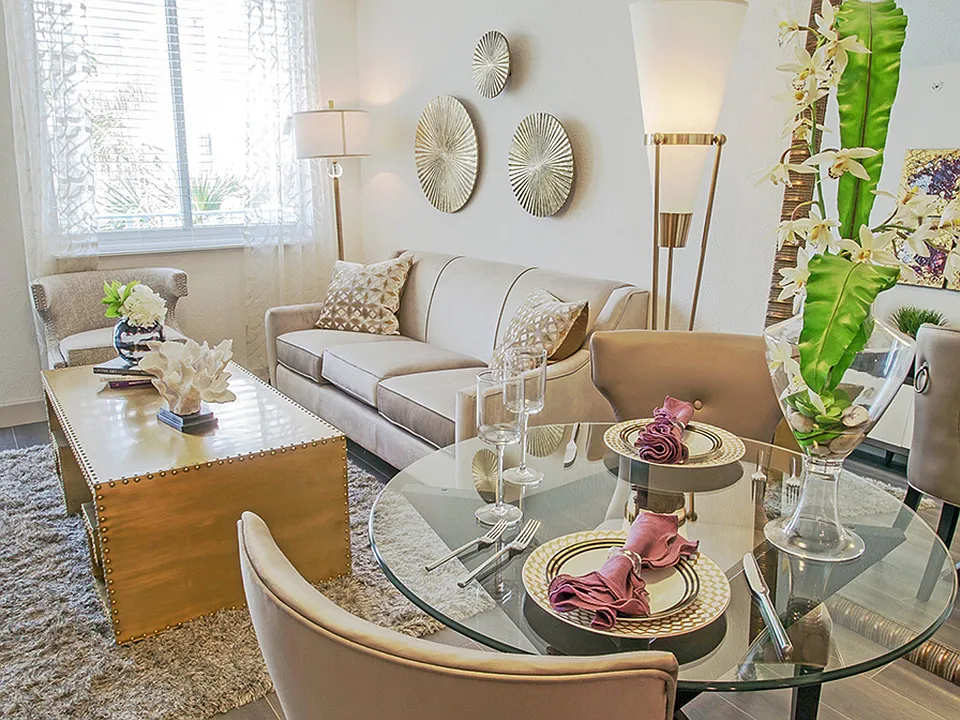 Luxury apartment living room with dining table, modern seating area, and large windows with natural light